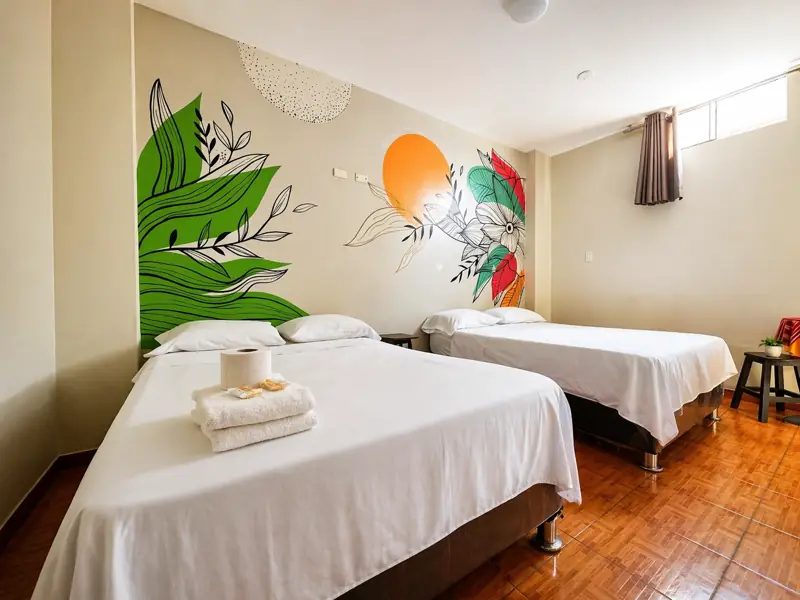Habitación Doble 2+1 con una cama matrimonial y una individual, y mural de hojas verdes con sol naranja