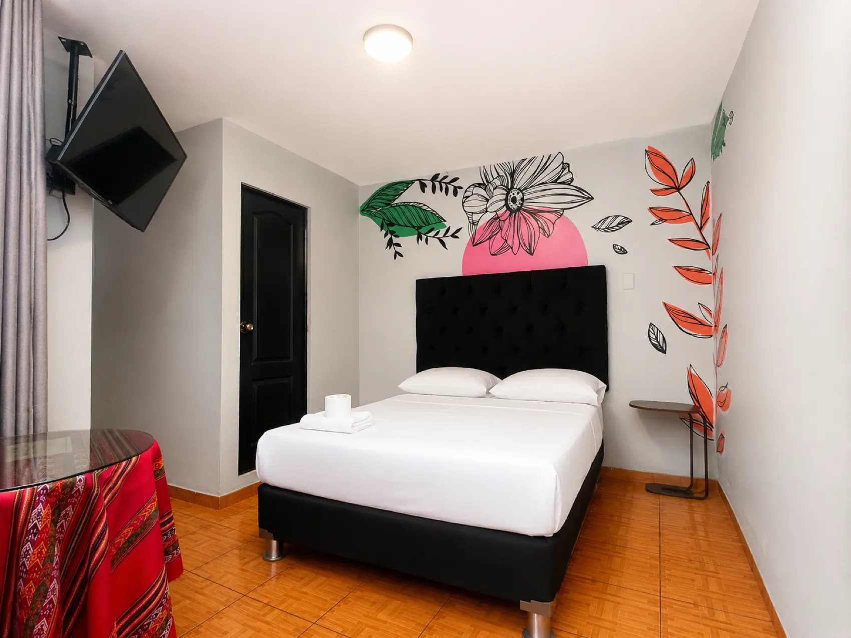 Mural de una flor blanca sobre un círculo rosa pintado a mano en la pared de una habitación